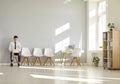 Job seeker with laptop in a row with empty chairs waiting for interview invitation turn Royalty Free Stock Photo