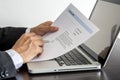 Job seeker review his resume on his desk with pen and computer l