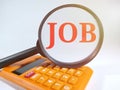 JOB,text on magnifying glass and calculator on white and soft flare background.