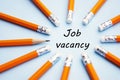 Job vacancy inscription. Yellow office pencils over blue background. Finding a job, looking for a job concept.