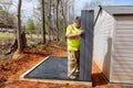 Job by a worker assembling plastic shed for backyard near the house