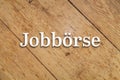 `JobbÃÂ¶rse` white text on a wooden background. Translation: `Job Market` Royalty Free Stock Photo