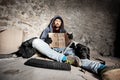 Jobless man sitting on city sidewalk with his dog Royalty Free Stock Photo