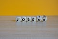 Jobs available? Turned a cubes and changes the word no to yes. Beautiful wooden table, yellow background.