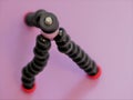 Joby GorillaPod Magnetic 325 a compact, flexible tripod with magnetic feet on a pink background