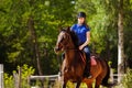 Jockey girl training horse at racetrack in summer Royalty Free Stock Photo