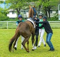 Jockeys and trainer get the horse on the start