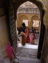 Numerous people in an arch of an inner courtyard of the Mehrangarh Fort in the blue city of Jodhpur, India