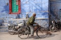 Indian mature man riding a bicycle on the street in old town of blue city Jodhpur, India Royalty Free Stock Photo