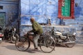 Indian mature man riding a bicycle on the street in old town of blue coty Jodhpur, India Royalty Free Stock Photo