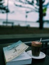 Joe dispenza book and coffee at beach cafe