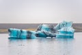 Joekulsarlon Glacier Lagoon deep blue iceberg with dark layers of volcanic ash forming pattern