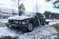 Damaged black car after a collision accident. Damaged old BMW