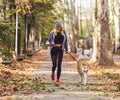 Jogger and akita dog running outdoors. Sports and healthy concept