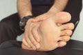 Jogger hands on foot. He is feeling pain as his ankle or foot is broken or twisted. Accident on running track during the morning Royalty Free Stock Photo