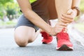 Jogger hands on foot. He is feeling pain as his ankle or foot is broken or twisted.