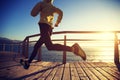 Jogger morning exercise on seaside boardwalk during sunrise Royalty Free Stock Photo