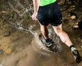 A jogger is running through a streambed