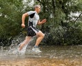 Jogger running through a streambed