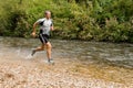 Jogger running through a streambed