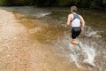 Jogger running through a streambed