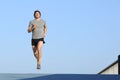 Jogger running towards camera on blue