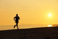 Jogger silhouette running on the beach at sunset