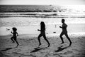 Joggers family have fun on beach run and jump at sunset. Father, mother, baby son run. Child jump with fun by water pool Royalty Free Stock Photo