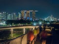 Joggers at Singapore`s Marina Barrage with city skyline