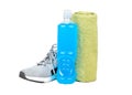 Jogging concept. Gray sneaker, towel and blue isotonic drinks bottle