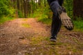 Jogging feet of a running man from low perspective in a green forest at springtime. Dynamic photo of a popular human