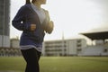 Young women warm up body. Sit back and Drink whey protein rest after running jogging on the running track around the football fie