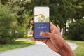 Jogging outdoors. Hand of african american man holding phone with app