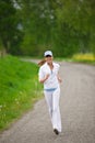 Jogging - sportive woman running on road in nature