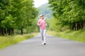 Jogging sportive young woman running park road