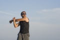 Jogging Summer workout - young attractive and fit runner man training on beautiful beach stretching arms before running by the sea Royalty Free Stock Photo