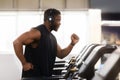 Muscular black man in modern wireless headphones running at gym Royalty Free Stock Photo