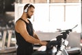 Jogging Workout. Young Muscular Man Wearing Wireless Headphones Using Treadmill At Gym Royalty Free Stock Photo