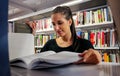 Female student reading in College Campus Library Royalty Free Stock Photo