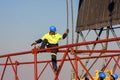 Construction worker hoisting a iron beam on a building site