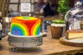 Rainbow coloured cake on display. Brightly coloured icing.