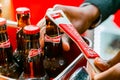 African barman opening a Budweiser bottles of beer in red branded ice bucket on bar counter Royalty Free Stock Photo