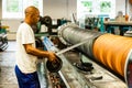 Diverse workers inside a rubber and pipe fabrication assembly line in a factory