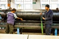 Diverse workers inside a rubber and pipe fabrication assembly line in a factory