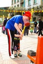 Child minder assisting a boy to hit a strength tester at outdoor funfair