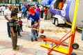 Child minder assisting a boy to hit a strength tester at outdoor funfair