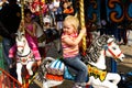 Kids riding on fairground carousel merry-go-round out outdoor funfair