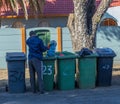 Unemployed man searching through rubbish bins