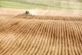 A John Deere tractor pulling a plowing implement, plows an Idaho farm field