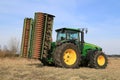 John Deere 8430 Agricultural Tractor with Ring Roller by Field